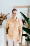 Gold Coast Acupuncturist in vyne health reception area staff photo with orange shirt and plant