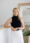 Gold Coast Birth Trauma Counsellor and Midwife at Vyne Health Shannons staff photo leaning on reception desk
